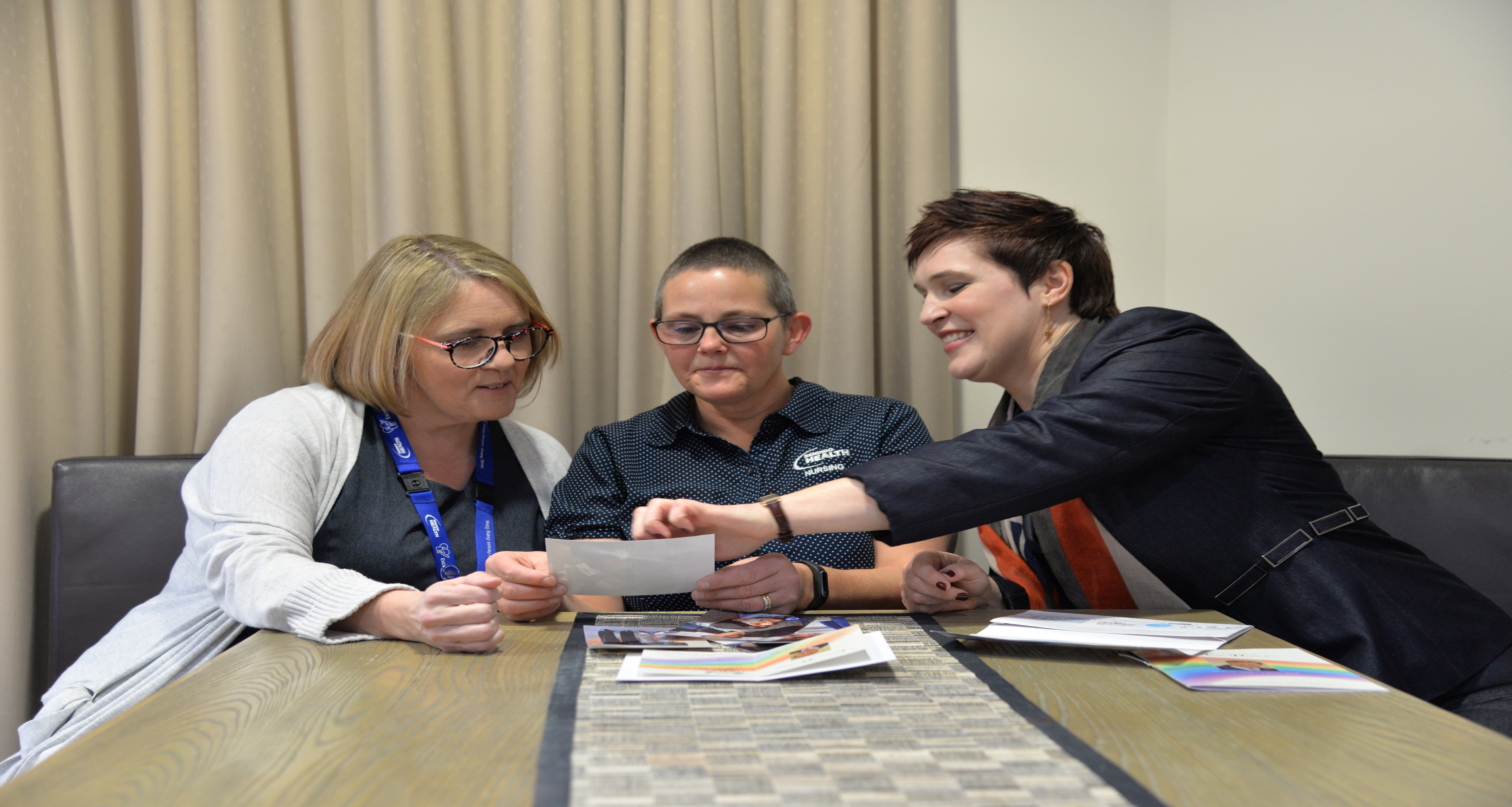 Jodhe Mattner’s (right) with Bendigo Health staff looking at photos of her late father, Lindsay.